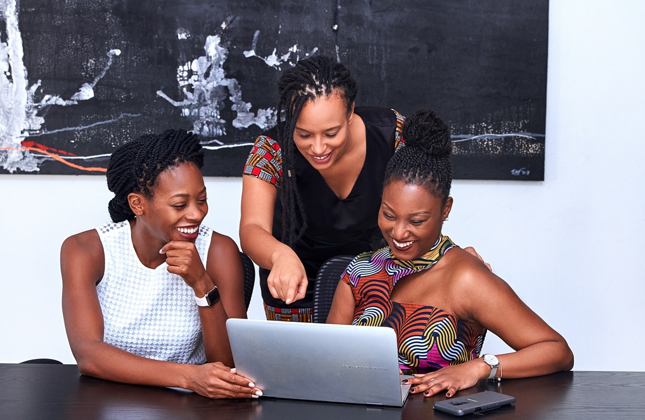 three african women working on a computer